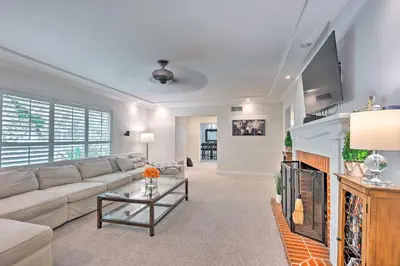 a living room with a couch and a tv at Bakersfield Oasis Sweet Tropical Pool Setup! in Bakersfield