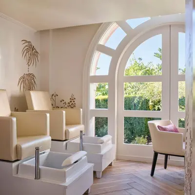 a waiting room with chairs and a large window at The Beverly Hills Hotel - Dorchester Collection in Los Angeles