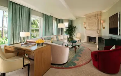 a living room with a couch and a fireplace at The Beverly Hills Hotel - Dorchester Collection in Los Angeles
