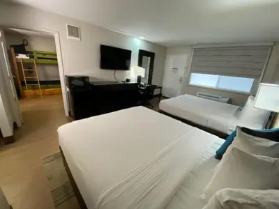 a hotel room with two beds and a television at Stanford Inn & Suites Anaheim in Anaheim