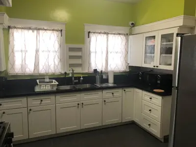 a kitchen with white cabinets and black counter tops at The Wilshire Metro in Los Angeles