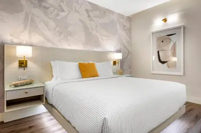 a bedroom with a large white bed and a wall at Cambria Hotel Calabasas - Malibu in Calabasas