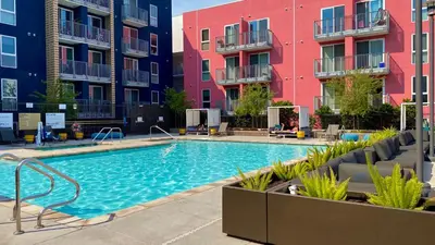 a swimming pool in front of some apartment buildings at Apart Hotel at Chinatown in Los Angeles