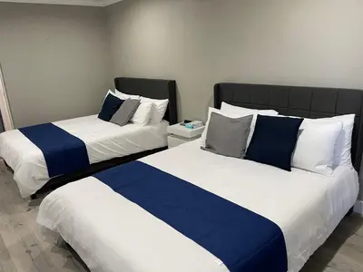 two beds sitting next to each other in a room at Omeo Suites in Alhambra