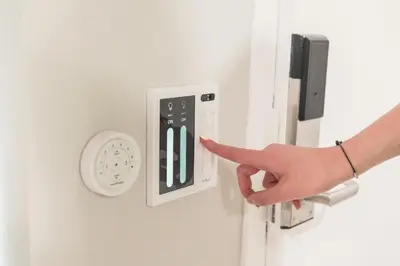 a person pointing at a light switch with their finger at Omeo Suites in Alhambra