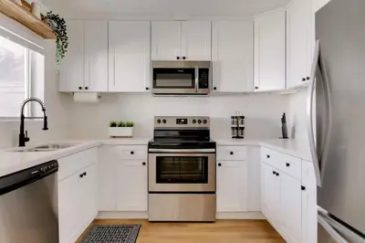 a kitchen with white cabinets and a stainless steel appliance at Sophisticated Long Beach Suite with Patio Dining and Parking NRP21-00185 in Long Beach