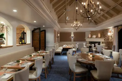 a dining room with tables and chairs and a chandelier at Westlake Village Inn in Westlake Village
