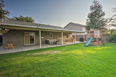 a backyard with a house and a playground at Family-Friendly Home, 6 Mi to Riverwalk Plaza in Bakersfield