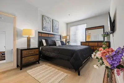 a bedroom with a bed and a dresser and a mirror at 1 Luxury Apartment in Los Angeles
