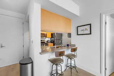 a kitchen with two bar stools and a counter at 1 Luxury Apartment in Los Angeles