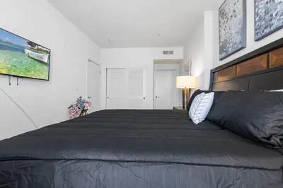 a bedroom with a large bed in a white room at 1 Luxury Apartment in Los Angeles