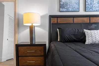 a bedroom with a bed and a lamp on a nightstand at 1 Luxury Apartment in Los Angeles