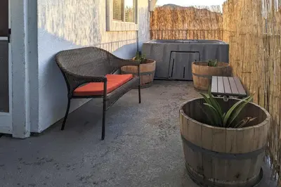 a patio with a chair and a bench and a table at 5 Mi to Universal Studios Family Gem with Hot Tub! in Burbank