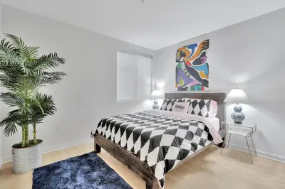a bedroom with a black and white bed and a plant at 10 Cozy apartment heart of Santa Monica in Los Angeles