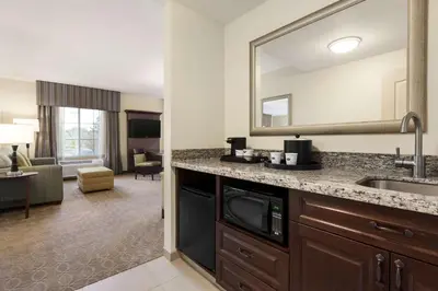 a kitchen with a sink and a mirror in a hotel room at Hampton Inn & Suites San Bernardino in San Bernardino