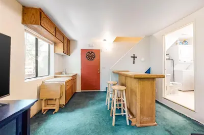 a small kitchen with a counter and a red door at Morrison Manor in Lake Arrowhead