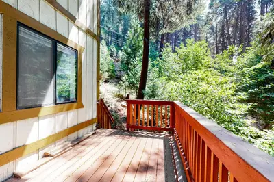 a balcony of a house with a view of the forest at Morrison Manor in Lake Arrowhead