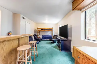 a kitchen with a bar and a living room at Morrison Manor in Lake Arrowhead