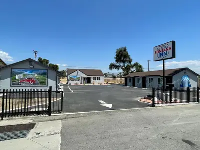 a parking lot with a sign for a car dealership at Fontana Inn in Fontana