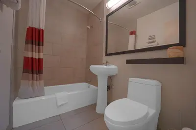 a bathroom with a toilet and a sink and a bath tub at Mojave Hotel in Mojave