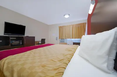 a hotel room with a bed and a flat screen tv at Mojave Hotel in Mojave