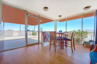 a dining room with a table and chairs and windows at Mojave Hotel in Mojave