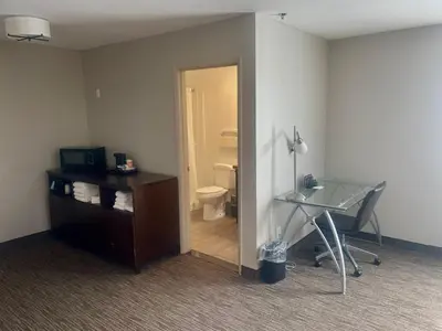 a room with a bathroom with a toilet and a glass desk at Country Inn & Suites by Radisson, Bakersfield, CA in Bakersfield