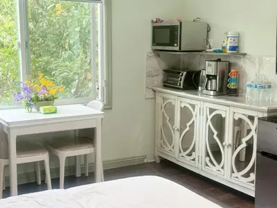 a kitchen with a white table and a microwave at \u534e\u4eba\u533a\u82b1\u56ed\u522b\u5885 in Temple City