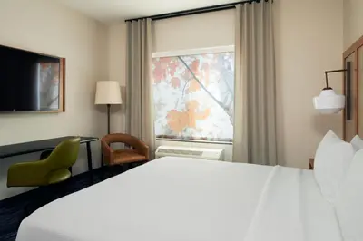 a hotel room with a large bed and a window at Fairfield by Marriott Inn & Suites Palmdale West in Palmdale
