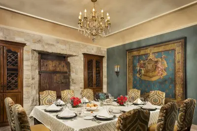 a dining room with a table and chairs and a chandelier at Ayres Hotel Manhattan Beach in Hawthorne