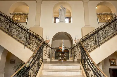 a staircase in a house with a statue on the wall at Ayres Hotel Manhattan Beach in Hawthorne