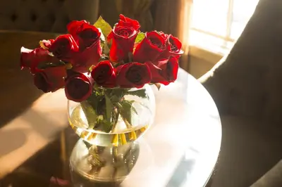 a vase filled with red roses on a table at Ayres Hotel Manhattan Beach in Hawthorne