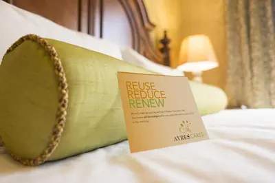 a hotel bed with a rescue reduce renew sign on it at Ayres Hotel Manhattan Beach in Hawthorne