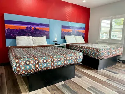 two beds in a room with red walls at La Casa Motel, Los Angeles - Burbank Airport in Sun Valley