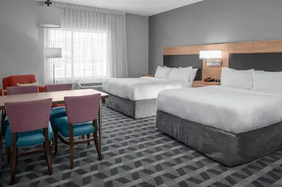 a hotel room with two beds and a table and chairs at TownePlace Suites By Marriott Tehachapi in Tehachapi