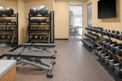 a gym with rows of exercise equipment and a flat screen tv at TownePlace Suites By Marriott Tehachapi in Tehachapi