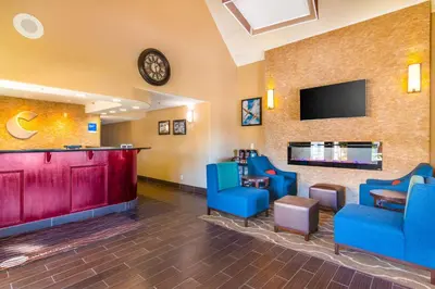 a waiting room with blue chairs and a bar at Comfort Inn & Suites Mojave in Mojave
