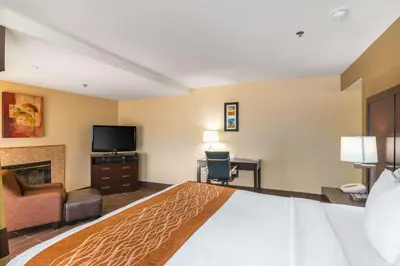 a hotel room with a bed and a flat screen tv at Comfort Inn & Suites Mojave in Mojave