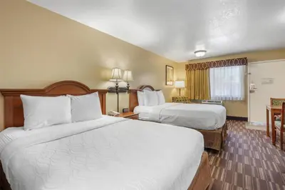a hotel room with two beds and a window at Best Western Desert Winds in Mojave