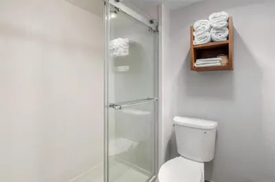 a bathroom with a shower with a toilet and towels at Best Western Desert Winds in Mojave