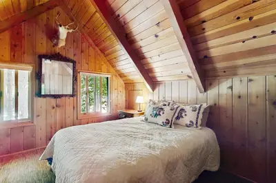 a bedroom with a bed in a wooden house at Wooded Comfort in Lake Arrowhead