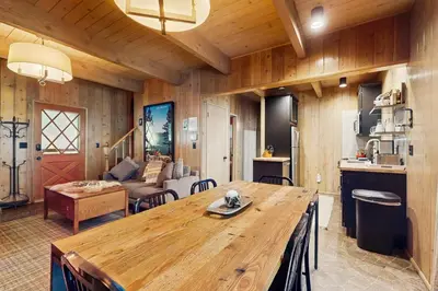 a living room with a wooden table and a couch at Wooded Comfort in Lake Arrowhead