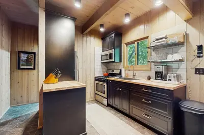 a kitchen with wooden walls and wooden counters at Wooded Comfort in Lake Arrowhead
