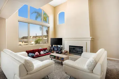 a living room with two white chairs and a fireplace at Seaside Getaway in Oxnard