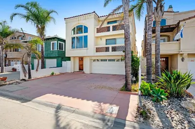 a house with palm trees in front of it at Seaside Getaway in Oxnard