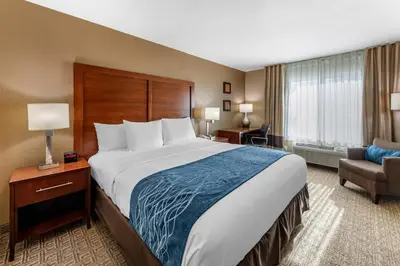 a hotel room with a large bed and a chair at Comfort Inn & Suites Ventura Beach in Ventura