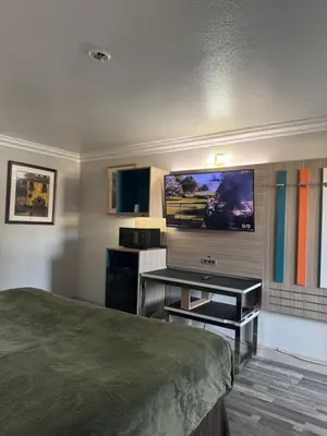 a hotel room with a bed and a flat screen tv at Rodeway Inn Ventura Midtown in Ventura