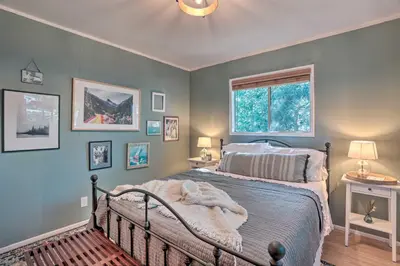 a bedroom with a bed and a window at Modern and Unique Cabin with Deck by Lake Gregory! in Crestline