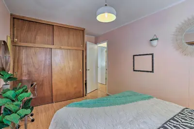 a bedroom with a bed and a wooden cabinet at Modern and Unique Cabin with Deck by Lake Gregory! in Crestline