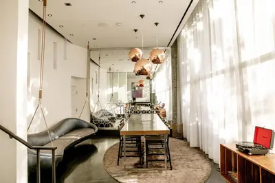 a dining room with a table and chairs and a mirror at W Los Angeles – West Beverly Hills in Los Angeles